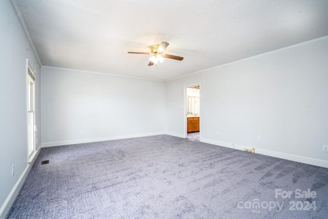 carpeted empty room with a textured ceiling, crown molding, and ceiling fan