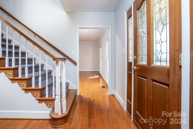 foyer with hardwood / wood-style flooring and a textured ceiling