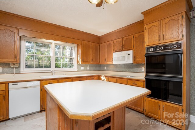 kitchen featuring white appliances, light tile patterned flooring, ceiling fan, sink, and a kitchen island