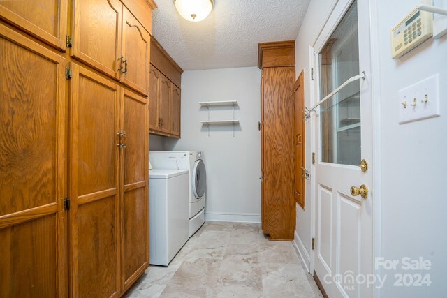 laundry room with cabinets, a textured ceiling, independent washer and dryer, and light tile patterned flooring