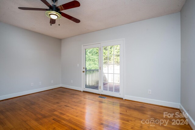 spare room with ceiling fan, hardwood / wood-style flooring, and a textured ceiling