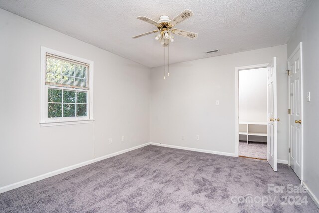 spare room with ceiling fan, a textured ceiling, and carpet flooring