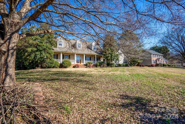 cape cod home with a porch and a front yard