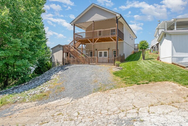 rear view of house with a deck and a yard