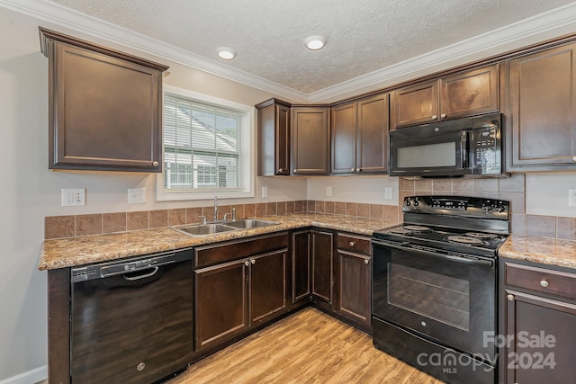 kitchen featuring sink, light hardwood / wood-style flooring, crown molding, and black appliances