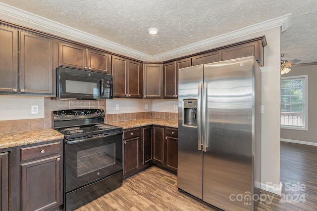 kitchen with ceiling fan, black appliances, ornamental molding, light hardwood / wood-style flooring, and light stone countertops