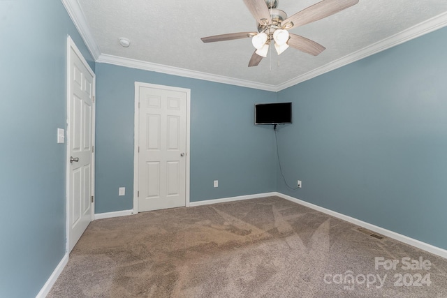 carpeted empty room with ornamental molding, ceiling fan, and a textured ceiling