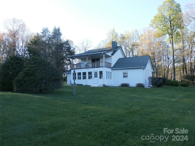 view of front of house with a balcony and a front yard