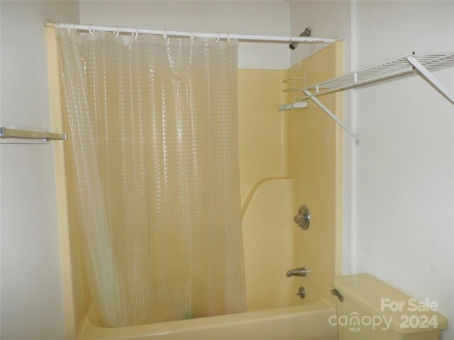 bathroom with shower / tub combo and toilet