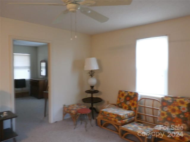 living area with ceiling fan and carpet floors