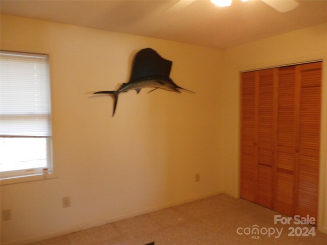 unfurnished bedroom with carpet, ceiling fan, and a closet