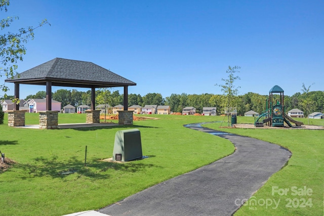 view of property's community featuring a gazebo, a playground, and a lawn