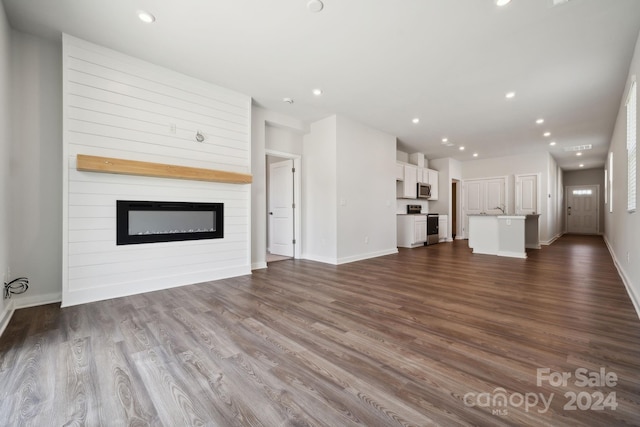 unfurnished living room featuring a large fireplace and hardwood / wood-style floors