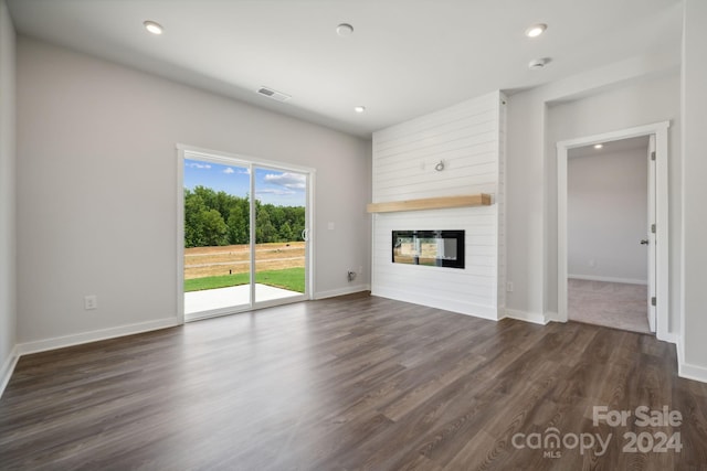 unfurnished living room with a fireplace and dark wood-type flooring