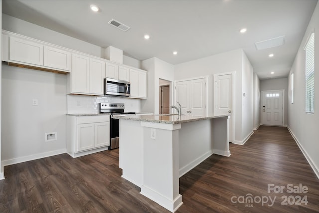 kitchen featuring appliances with stainless steel finishes, dark wood-type flooring, sink, a center island with sink, and white cabinets