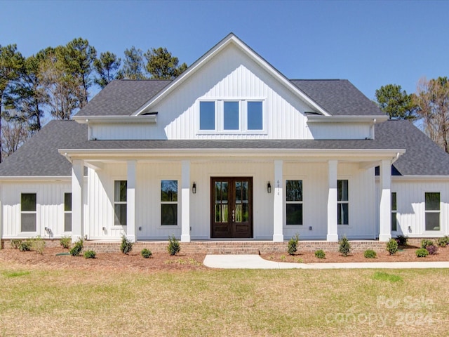 modern farmhouse style home with a front yard and a porch