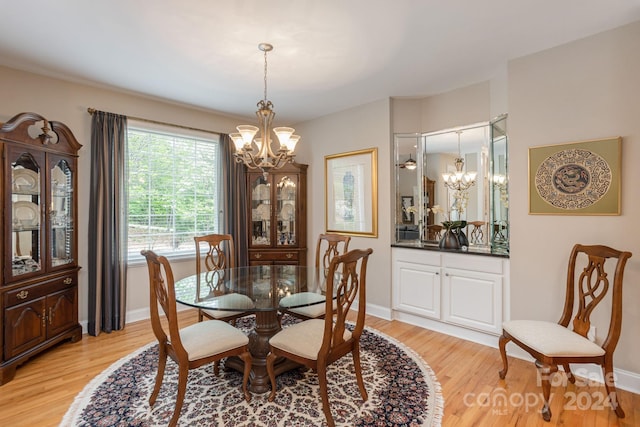 dining space featuring light wood-type flooring and an inviting chandelier