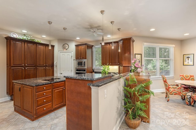 kitchen with decorative light fixtures, kitchen peninsula, appliances with stainless steel finishes, and a center island