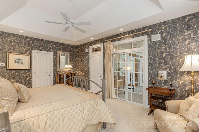 bedroom featuring ceiling fan, carpet, a raised ceiling, and access to outside