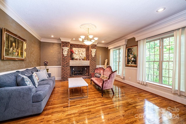 living room with ornamental molding, wood-type flooring, and a brick fireplace