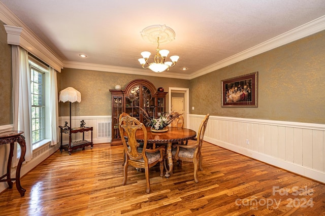 dining room featuring a chandelier, crown molding, and wood-type flooring