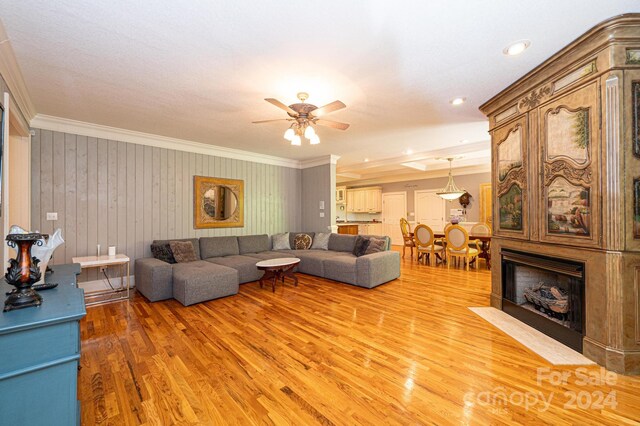 living room featuring ceiling fan, crown molding, and hardwood / wood-style flooring