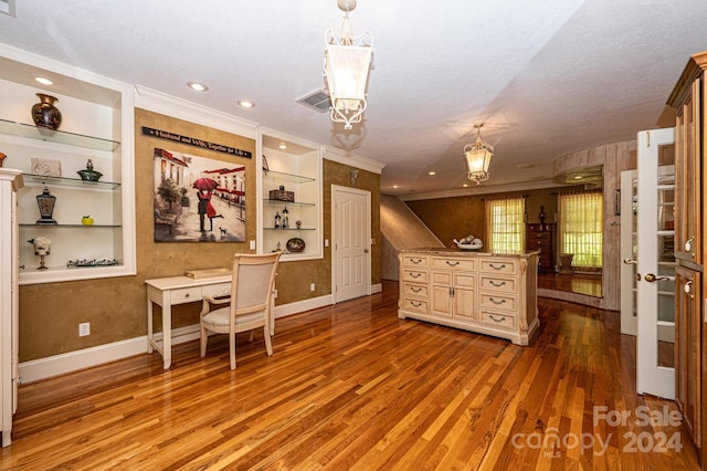 interior space featuring built in features, crown molding, hardwood / wood-style flooring, and a textured ceiling