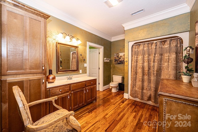 bathroom with ornamental molding, wood-type flooring, oversized vanity, and toilet