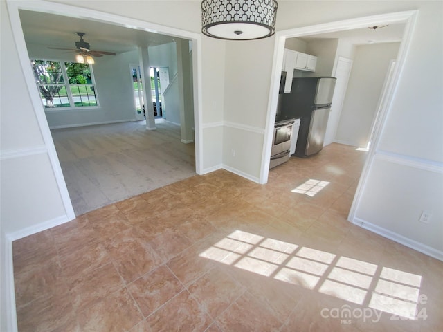 spare room with ceiling fan and light tile floors