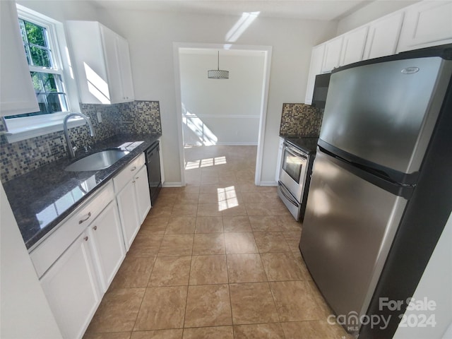 kitchen featuring tasteful backsplash, white cabinetry, stainless steel appliances, and light tile floors