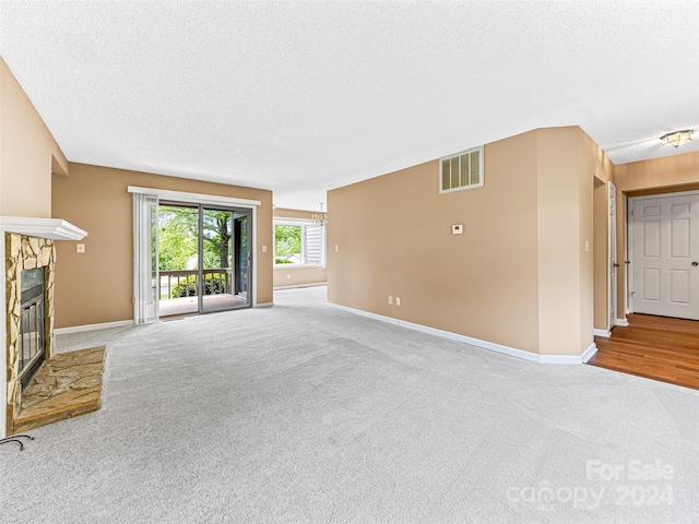 unfurnished living room with hardwood / wood-style flooring and a textured ceiling