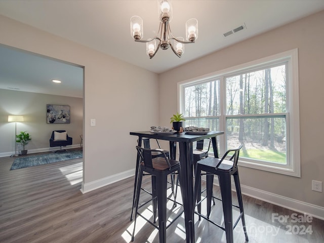 dining space with a wealth of natural light, a chandelier, and dark hardwood / wood-style floors