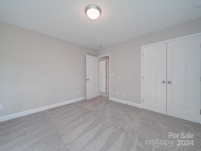 unfurnished bedroom with a closet and carpet flooring