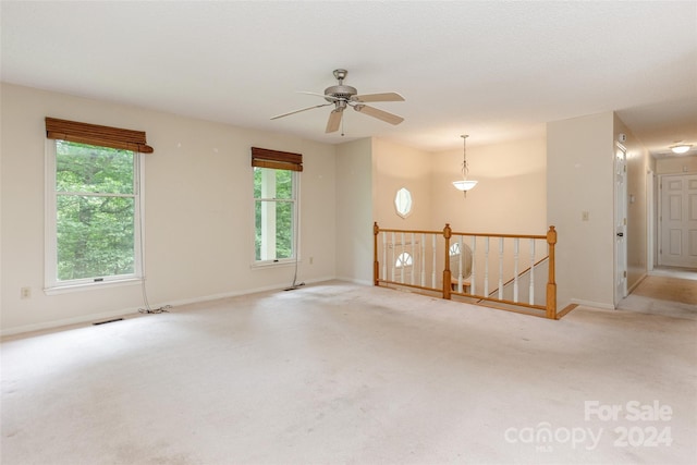 carpeted spare room with ceiling fan and a healthy amount of sunlight