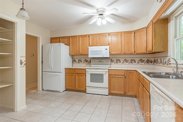 kitchen with a textured ceiling, sink, hanging light fixtures, and white appliances