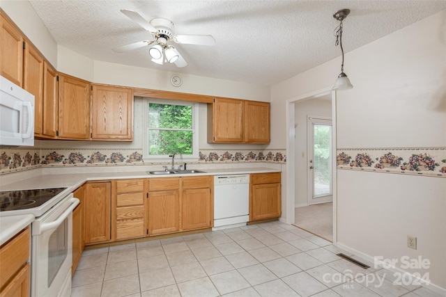 kitchen with a textured ceiling, sink, decorative light fixtures, and white appliances