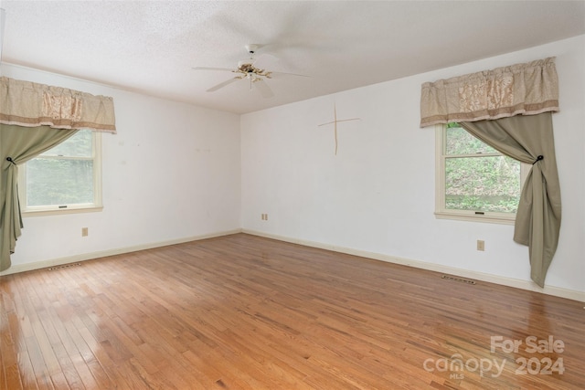 spare room with a textured ceiling, hardwood / wood-style flooring, and ceiling fan