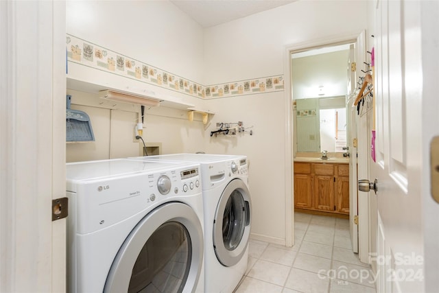 laundry area featuring independent washer and dryer, sink, and light tile patterned floors