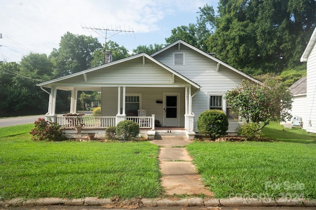 bungalow-style home with a front lawn and a porch