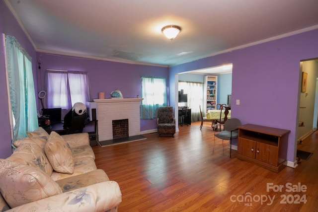 living room with crown molding, a fireplace, and hardwood / wood-style floors