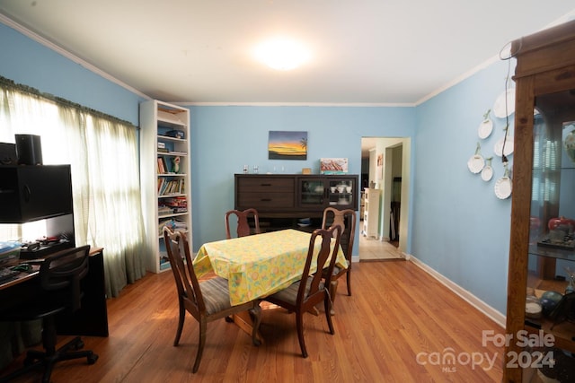 dining room featuring crown molding and light hardwood / wood-style flooring