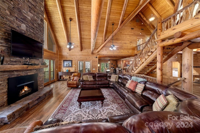 living room featuring hardwood / wood-style floors, wooden ceiling, wood walls, and a stone fireplace