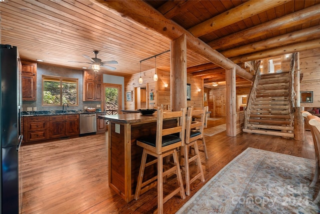 kitchen with wooden ceiling, light hardwood / wood-style flooring, black refrigerator, and rustic walls