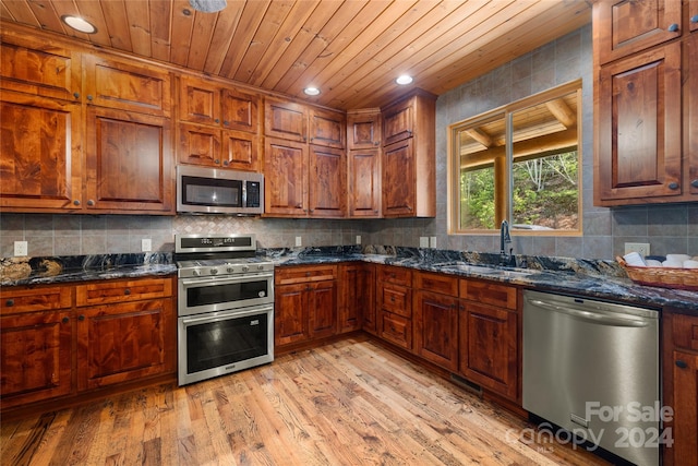 kitchen with sink, light hardwood / wood-style floors, backsplash, and stainless steel appliances