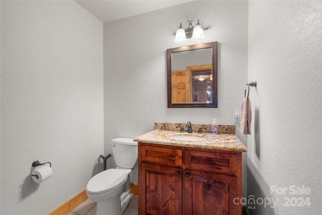 bathroom with vanity, toilet, and tile flooring