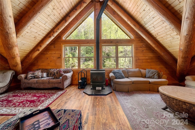 living room featuring wooden ceiling, beam ceiling, a wood stove, and wood-type flooring