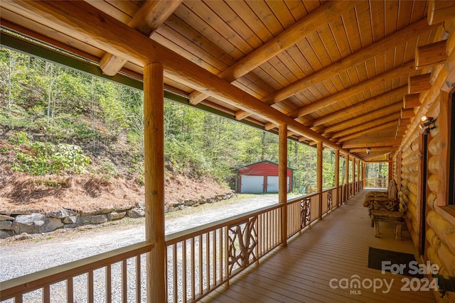 wooden deck featuring a garage and an outdoor structure