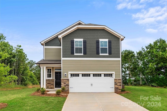 craftsman house featuring a garage and a front lawn