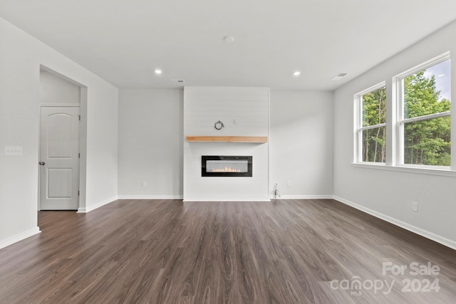 unfurnished living room featuring a fireplace and dark hardwood / wood-style floors