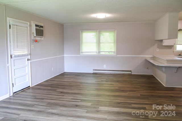 kitchen with white cabinetry, a baseboard heating unit, wood-type flooring, a textured ceiling, and ornamental molding